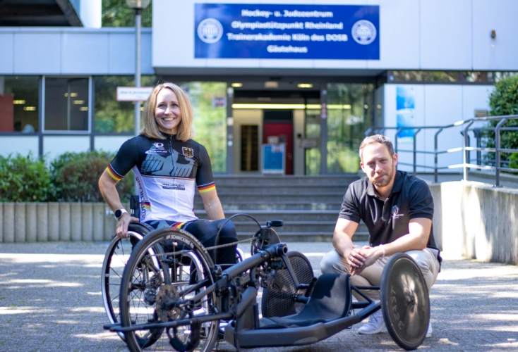 Para-Radsportlerin Annika Zeyen mit OSP-Leiter Daniel Müller vor der OSP-Zentrale in Köln (Bild: OSP NRW/Rheinland; Sebastian Meyer-Köring)